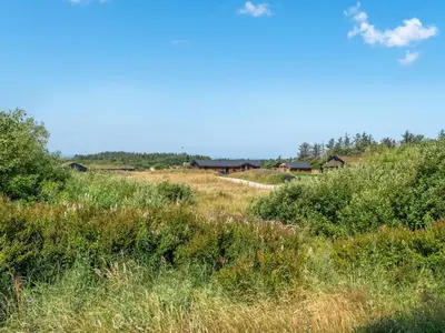 a field of grass with houses in the background at Holiday Home Ilya - 1-7km from the sea by Interhome in Saltum