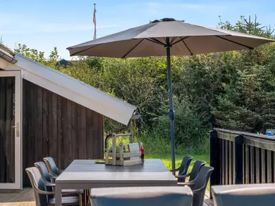 a table with an umbrella on a patio at Holiday Home Ilya - 1-7km from the sea by Interhome in Saltum
