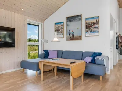 a living room with a blue couch and a table at Holiday Home Ilya - 1-7km from the sea by Interhome in Saltum