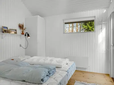 two beds in a room with white walls and a window at Holiday Home Elisabete - 200m to the fjord by Interhome in Fur