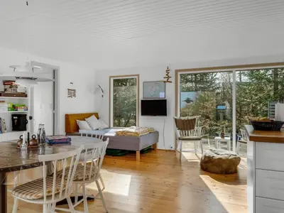 a kitchen and living room with a couch and a table at Holiday Home Elisabete - 200m to the fjord by Interhome in Fur