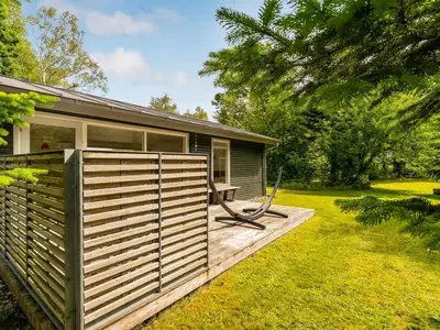 a tiny house with a deck and a bench at Holiday Home Elisabete - 200m to the fjord by Interhome in Fur