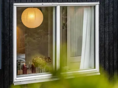 a window with a white curtain and a lamp at Holiday Home Godja - 1km from the sea by Interhome in Blokhus