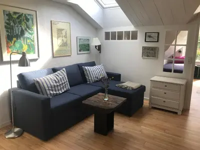a living room with a blue couch and a table at Kornloftet i Lodbjerg in Vestervig