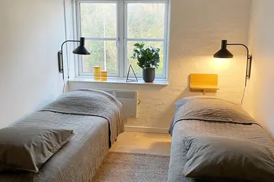 two beds in a room with a window at Cozy Scandinavian Apartment in the Heart of Viborg in Viborg