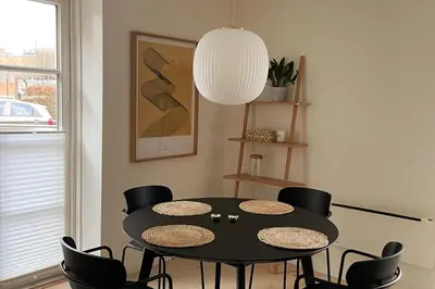 a dining room with a black table and chairs at Cozy Scandinavian Apartment in the Heart of Viborg in Viborg