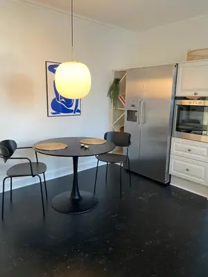 a kitchen with a table and chairs and a refrigerator at Modern Scandinavian Apartment in Viborg Centre in Viborg