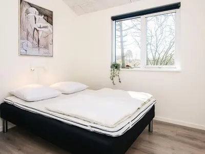 a bed in a white room with a window at 5 star holiday home in Løgstrup in Løgstrup