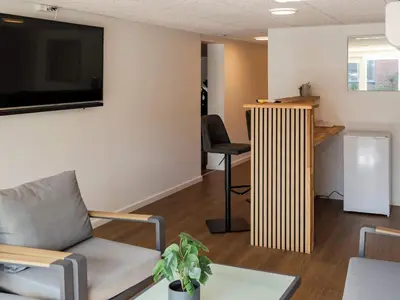 a living room with a couch and a flat screen tv at 5 star holiday home in Blokhus in Blokhus