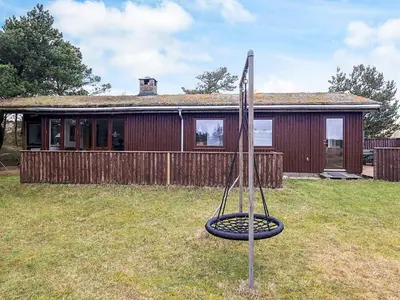 a house with a swing in the yard at 6 person holiday home in Pandrup in Pandrup