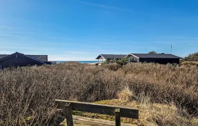 a wooden bench sitting in the middle of a field at 3 Bedroom Cozy Home In Løkken in Løkken