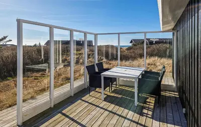a balcony with a table and chairs on a deck at 3 Bedroom Cozy Home In Løkken in Løkken