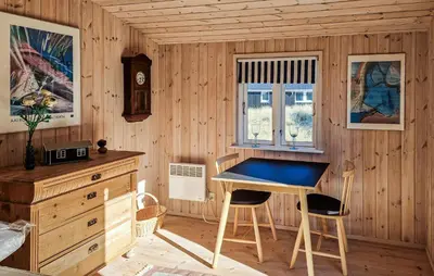 a desk in a wooden room with a table and two chairs at 3 Bedroom Cozy Home In Løkken in Løkken