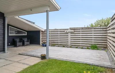 a backyard with a fence and a wooden deck at 2 Bedroom Stunning Home In Vinderup in Vinderup