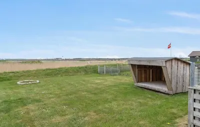 a smallshed in a field with a fence at 2 Bedroom Stunning Home In Vinderup in Vinderup