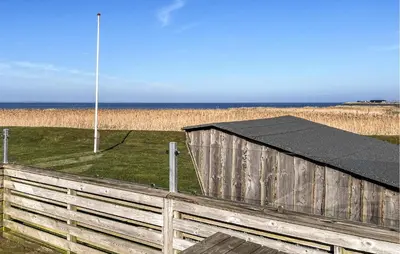 a wooden fence with a black roof on the beach at 2 Bedroom Stunning Home In Vinderup in Vinderup