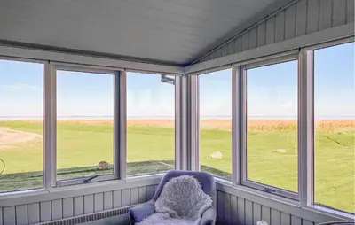 a room with windows with a chair and a field at 2 Bedroom Stunning Home In Vinderup in Vinderup