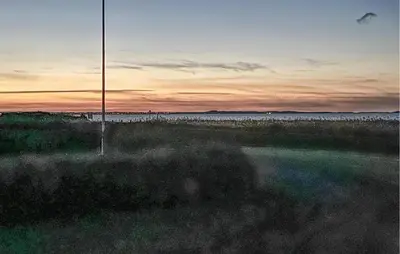 a sunset in a field with a pole in the grass at 2 Bedroom Stunning Home In Vinderup in Vinderup