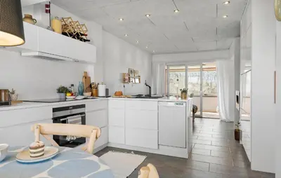 a kitchen with white cabinets and a table at Cozy Apartment In Lemvig With Sauna in Lemvig