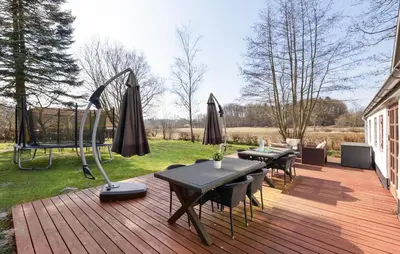 a wooden deck with tables and umbrellas on it at Nice Home In Farsø With Wifi in Farsø