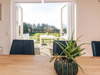 a potted plant sitting on a table in front of a window at 4 star holiday home in Løkken in Løgsted
