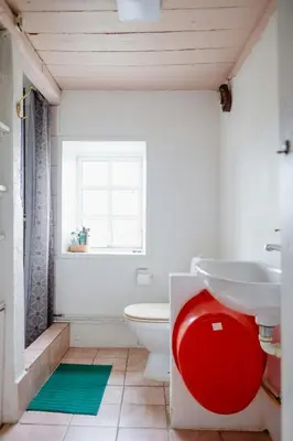 a bathroom with a toilet and a sink and a window at Cut Branches, Make Fire And Gaze At Treetops in Nykøbing Mors