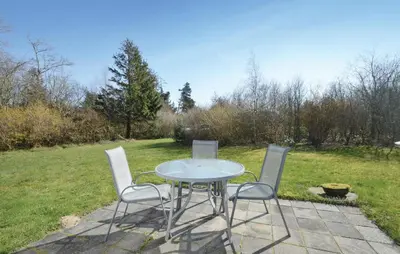 a table and four chairs sitting on a patio at 2 Bedroom Nice Home In Roslev in Roslev