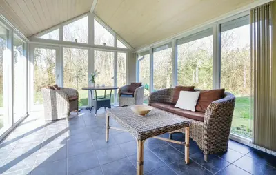 a screened in porch with chairs and a table at 2 Bedroom Nice Home In Roslev in Roslev