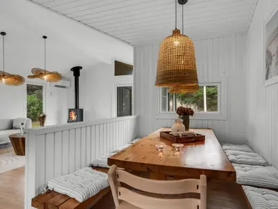 a dining room with a wooden table and a lamp at Holiday Home Gundborg - 200m from the sea by Interhome in Saltum