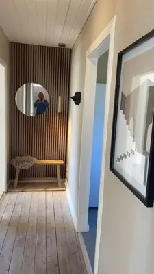 a hallway with a mirror and a bench in a room at Stor lys lejlighed på 100 kvm, central beliggenhed in Holstebro