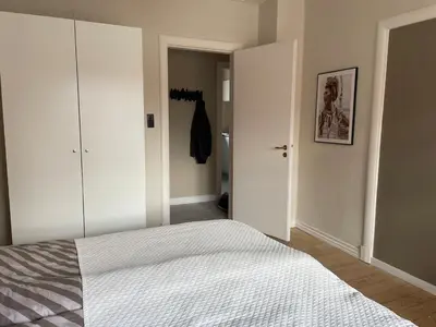 a bedroom with a white bed and a closet at Stor lys lejlighed på 100 kvm, central beliggenhed in Holstebro