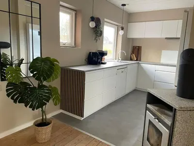 a kitchen with white cabinets and a potted plant at Stor lys lejlighed på 100 kvm, central beliggenhed in Holstebro