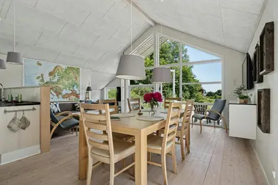 a kitchen and dining room with a table and chairs at Forest House With Stream By Hjarbæk Fjord in Højslev