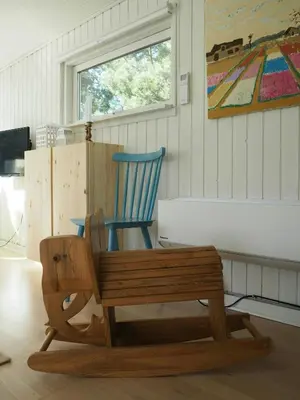 a wooden bench with a blue chair in a room at Traditional Holiday Home At Cold Hawaii in Torsted