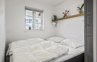 a white bed in a room with a window at Nice Home In Blokhus With Wifi in Blokhus