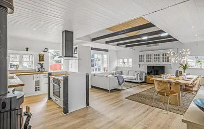 a kitchen and living room with a couch and a table at Nice Home In Blokhus With Wifi in Blokhus