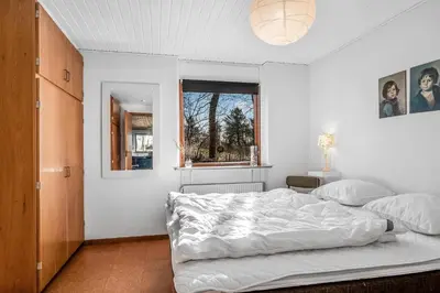 a bedroom with a large white bed and a window at Cozy Holiday Home Near Lild Strand in Frøstrup