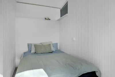a bedroom with a bed in a white room at Lovely Holiday Home With Panoramic View Of The Fjord in Amtoft