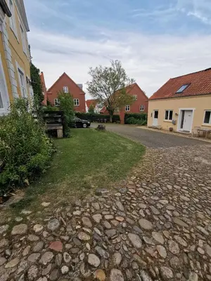 a cobblestone street in a village with houses at Cozy base near the cathedral in Viborg