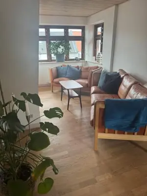 a living room with a leather couch and a table at Svane's Air-bnb in Nykøbing Mors