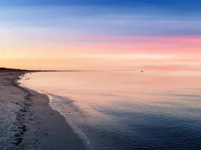 a view of the beach at sunset at 4 star holiday home in Løgstør in Løgsted