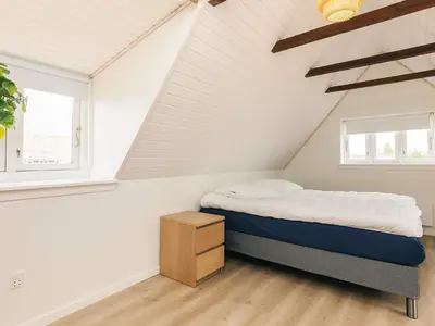 a bedroom with a bed and two windows at 4 star holiday home in Løgstør in Løgsted