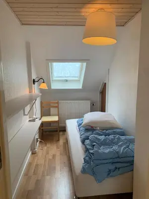 a bedroom with a bed and a desk and a window at Townhouse centrally located close to Jesperhus in Nykøbing Mors