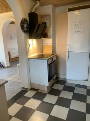 a kitchen with a white refrigerator and a checkered floor at Townhouse centrally located close to Jesperhus in Nykøbing Mors