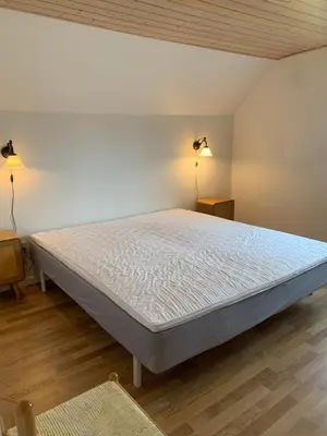 a large bed in a room with two lamps at Townhouse centrally located close to Jesperhus in Nykøbing Mors
