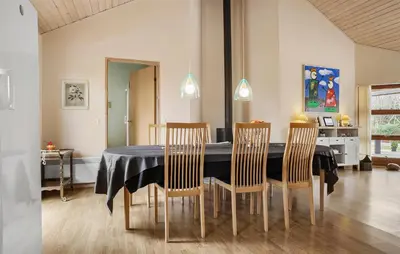 a dining room with a black table and chairs at Cozy Home In Spøttrup With Sauna in Spottrup