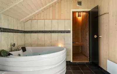 a large white tub in a bathroom with a door at Gorgeous Home In Vinderup With Sauna in Vinderup