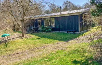 a blue shed with a bench in a yard at 4 Bedroom Amazing Home In Hurup Thy in Sønder Ydby