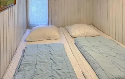 two twin beds in a small room with a window at 4 Bedroom Amazing Home In Hurup Thy in Sønder Ydby