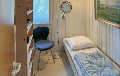 a room with a bed and a chair and a window at 4 Bedroom Amazing Home In Hurup Thy in Sønder Ydby